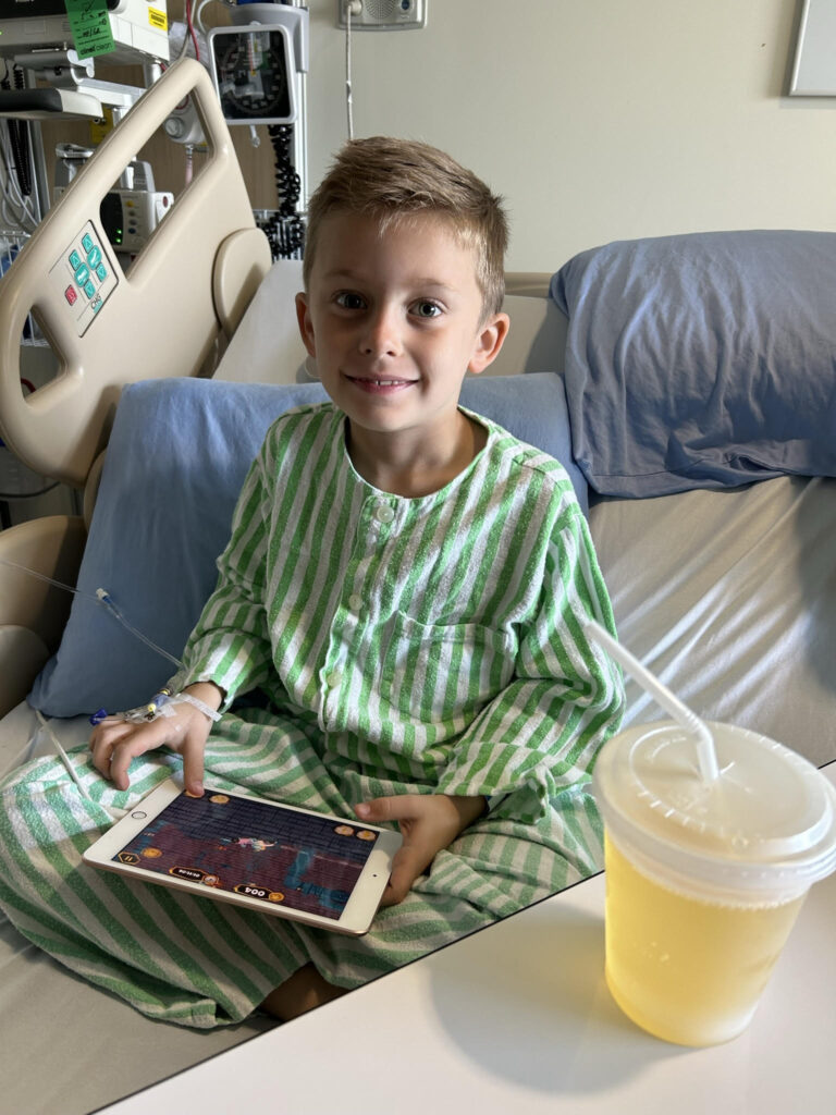 Young boy in a hospital bed with an ipad
